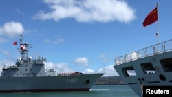 FILE - A Chinese People's Liberation Army (PLA) Navy replenishment ship (L) sails past a PLA Navy hospital ship.