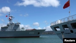 參加2014環太平洋聯合軍演的中國海軍“千島湖”綜合補給艦（左）2014年6月24日駛過停泊在美國夏威夷軍港裡的中國海軍醫療船“和平方舟”。