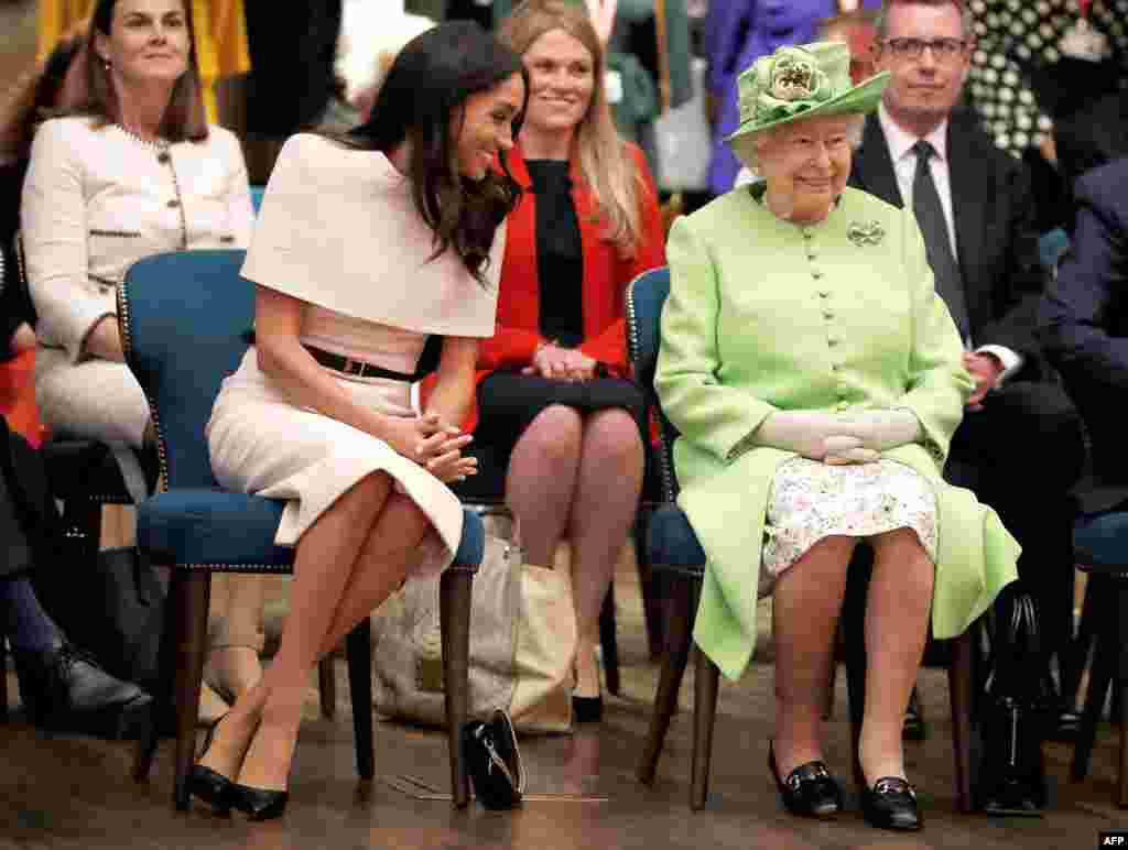 Britain's Queen Elizabeth II and Meghan, Duchess of Sussex gesture during their visit to the Storyhouse in Chester, Cheshire on June 14, 2018.