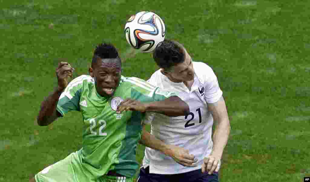 Nigeria's Kenneth Omeruo, left, and France's Laurent Koscielny go for a header during the World Cup round of 16 soccer match between France and Nigeria at the Estadio Nacional in Brasilia, Brazil, June 30, 2014.