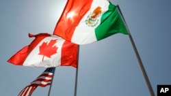 FILE - National flags representing the United States, Canada, and Mexico fly in the breeze, April 21, 2008.