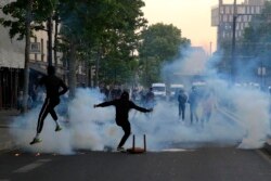 Demonstran menendang tabung gas air mata saat demonstrasi Selasa, 2 Juni 2020 di Paris.