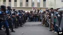 Police and protesters face off after a May Day march turned violent, in San Juan, Puerto Rico, May 1, 2018.