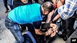 Polisi Turki menahan seorang demonstran anti KTT G-20 di Antalya, Turki (15/11).