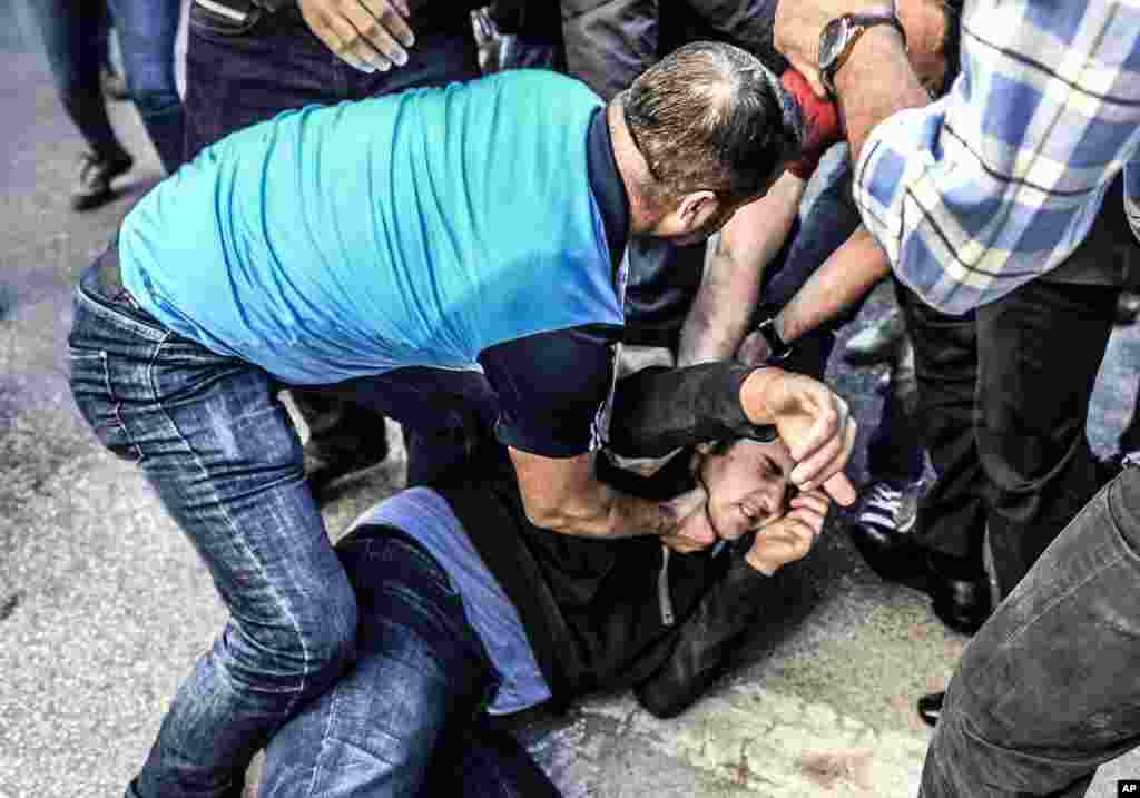 Police detains a leftist demonstrator during an anti-G20 protest in Antalya, Turkey.