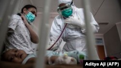 Seorang dokter merawat bayi yang dites positif virus corona COVID-19 di sebuah rumah sakit di Bogor pada 23 Juni 2021. Di Yogya, varian delta mendominasi kasus COVID, setengahnya anak-anak. (Foto: AFP/Aditya Aji)