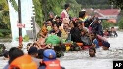Residents ride a makeshift raft as they evacuate their flooded homes in Makassar, South Sulawesi, Indonesia, Jan. 23, 2019. 