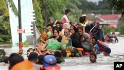 Warga naik rakit darurat saat dievakuasi dari rumah kediaman mereka yang terdampak banjir di Makassar, Sulawesi Selatan, 23 Januari 2019. 