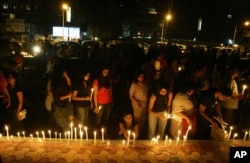 FILE - Members of the public observe a candlelight vigil for the victims of terrorist attacks in which scores were killed, in Mumbai, India, Nov. 29, 2008.