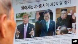 지난 11일 도널드 트럼프 미국 대통령, 문재인 한국 대통령, 김정은 북한 국무위원장이 나란히 보이는 신문 기사를 노년 남성이 읽고 있다. 