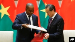 China's Foreign Minister Wang Yi, right, and Burkina Faso Foreign Minister Alpha Barry attend a signing ceremony establishing diplomatic relations between the two countries in Beijing, May 26, 2018.