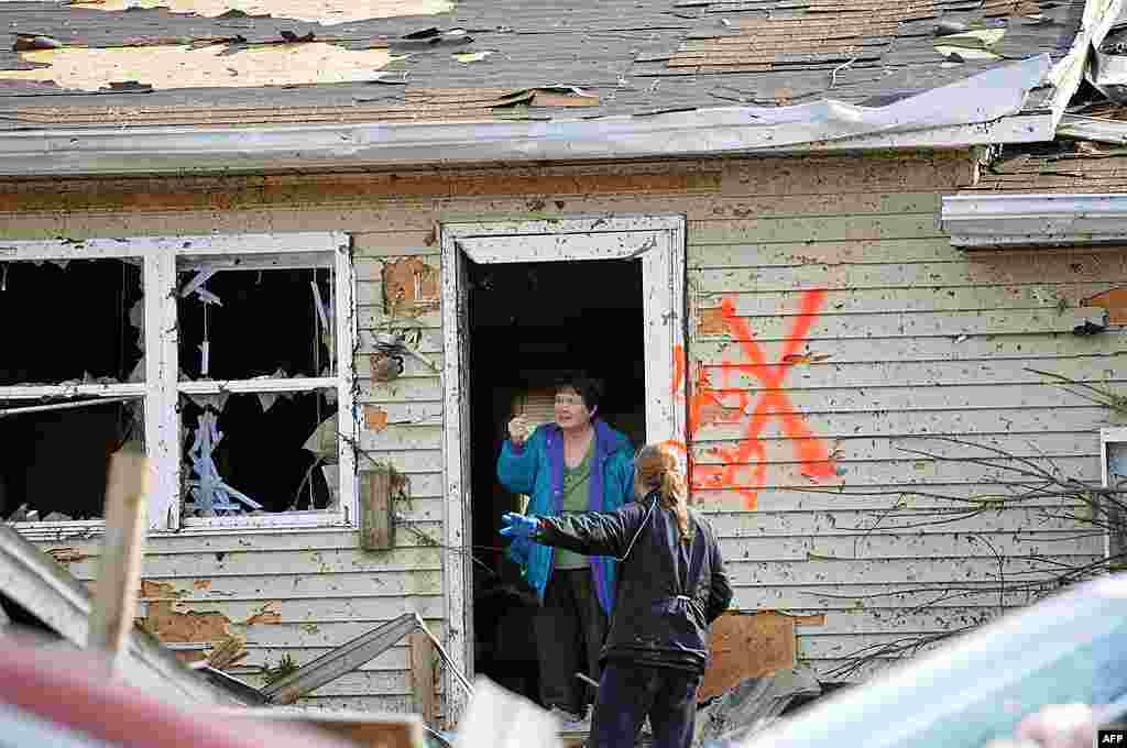 Margaret Shimkus, 61, talks with an emergency responder about her condition at her home in Harrisburg, Illinois, February 29, 2011. (AP) 