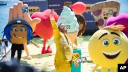 FILE - Actor T. J. Miller poses with characters for the film "The Emoji Movie," at the 70th international film festival, Cannes, May 16, 2017. 