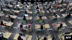 Registered teachers wearing face masks and shields against Covid-19, conduct a teleconferencing with stuggling students helping them in their school lessons through online distant learning at a local government-sanctioned online tutorial class in Taguig C