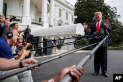 President Donald Trump speaks with reporters on the South Lawn of the White House, Oct. 8, 2018, in Washington.