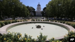 In this photo, taken July 21, 2014, is the unused water fountain located across the street from the state Capitol in Sacramento, Calif. The fountain was drained for repairs, but due to the drought, the repairs and refilling the fountain have been delayed. (AP Photo/Rich Pedroncelli)