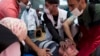 امدادگران در حال کمک به یک مجروح فلسطینی در نوار غزه 