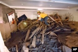Santa Barbara County firefighter Vince Agapito searches through a Montecito, Calif., home, Jan. 13, 2018, that was destroyed by deadly mudflow and debris early Tuesday following heavy rainfall.