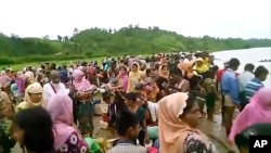 An Oct. 5, 2017, image taken from a video released by Arakan Rohingya National Organization shows villagers preparing to cross a river towards the Maungdaw township in the Rakhine state that borders Bangladesh.