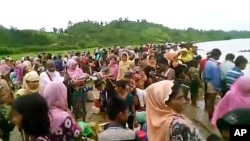 An Oct. 5, 2017 image taken from a video released by Arakan Rohingya National Organization shows villagers preparing to cross a river towards the Maungdaw township in the Rakhine state that borders Bangladesh. 