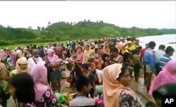 An Oct. 5, 2017 image taken from a video released by Arakan Rohingya National Organization shows villagers preparing to cross a river towards the Maungdaw township in the Rakhine state that borders Bangladesh.