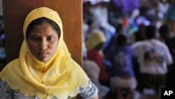 A Rohingya woman stands at a temporary shelter in Bayeun, Aceh Province, Indonesia, Monday, June 1, 2015. 