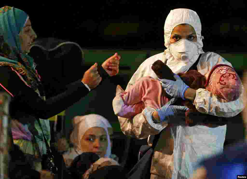 A child is carried by a rescue worker upon arrival at the Sicilian harbor of Pozzallo, April 19, 2015.