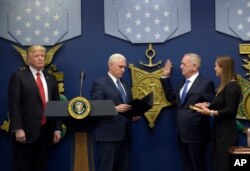 President Donald Trump, left, listens as Vice President Mike Pence, second from left, performs a ceremonial swearing-in for Defense Secretary James Mattis, second from right, at the Pentagon in Washington, Jan. 27, 2017.