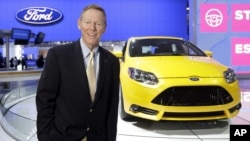 FILE - Ford President and CEO Alan Mulally stands by a Ford Focus during the North American International Auto Show in Detroit, Jan. 15, 2013.