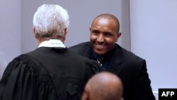 L'ancien chef de guerre congolais Bosco Ntaganda salue son avocat Stéphane Bourgon, dans la salle d'audience de la Cour pénale internationale lors des déclarations finales de son procès à La Haye, le 28 août 2018.