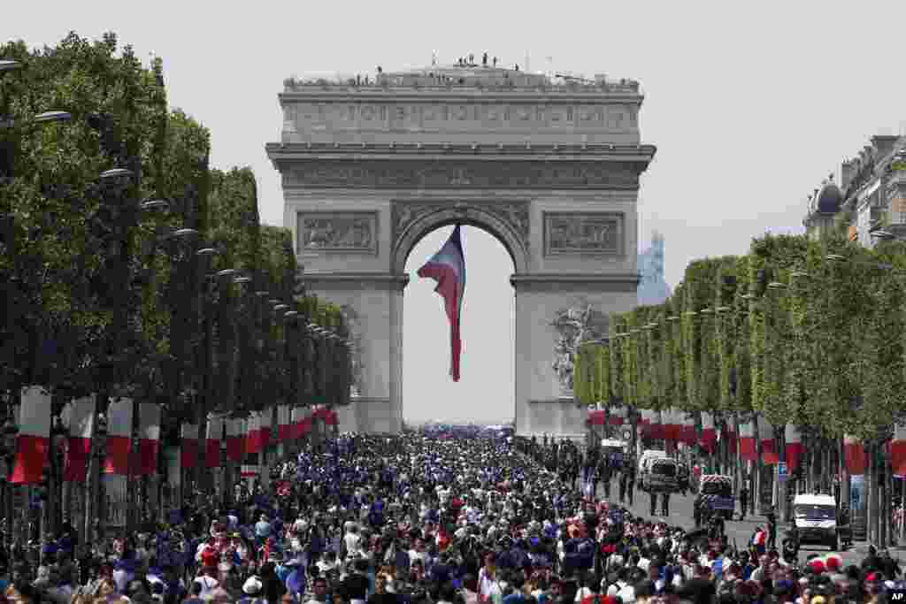 The crowd gathers to welcome the French soccer team for a parade a day after the French team victory in the soccer World Cup, July 16, 2018 in Paris. 
