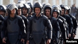FILE - Riot police take their positions outside a police academy, where ousted Egyptian President Mohamed Morsi's second trial session was due to take place outside Cairo on January 8, 2014. 