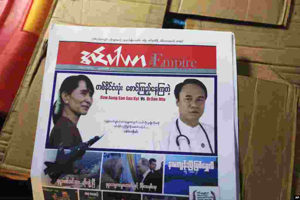 Soe Min (R) and Aung San Suu Kyi on the cover of a newspaper in Thartike village in Kawhmu township, March 25, 2012. (Reuters)