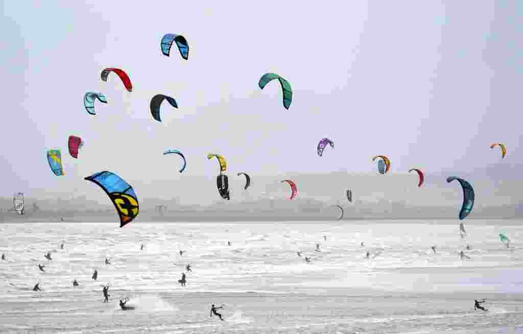 Kite surfers enjoy the strong winds on the beach on the warmest New Year on record, in Camber, East Sussex, England, Jan. 2, 2022.