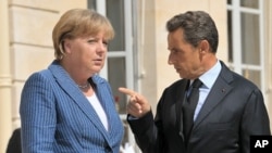 France's President Nicolas Sarkozy welcomes German Chancellor Angela Merkel as she arrives for a meeting at the Elysee Palace in Paris, August 16, 2011