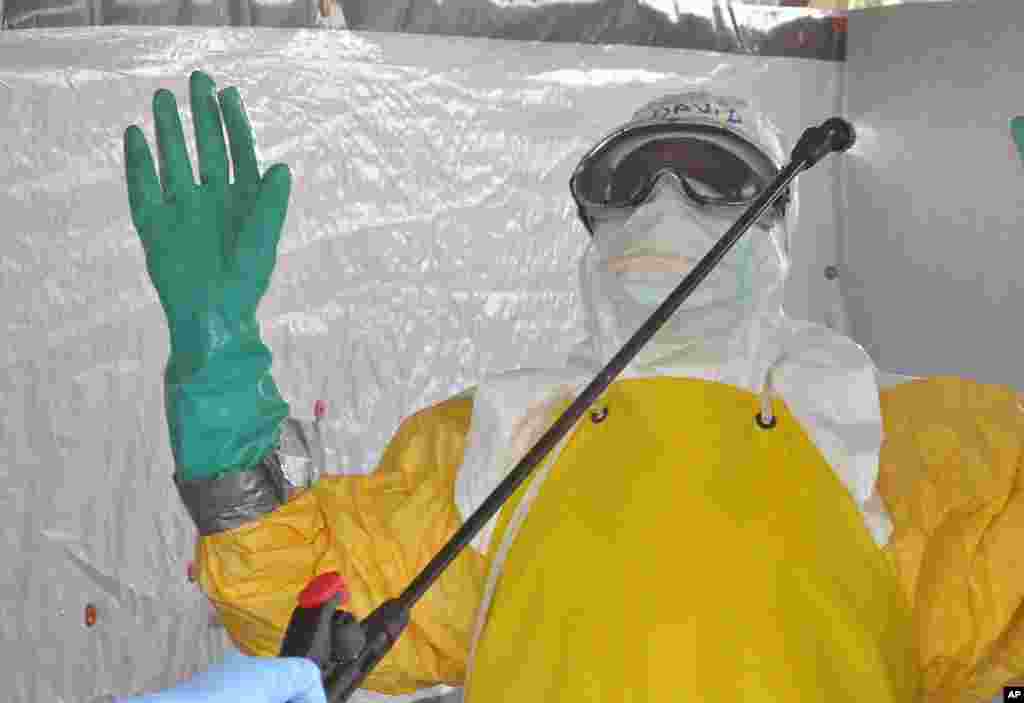 A health worker is sprayed with disinfectant after he worked with patients infected with the Ebola virus, at a clinic in Monrovia, Liberia, Sept. 8, 2014.&nbsp;