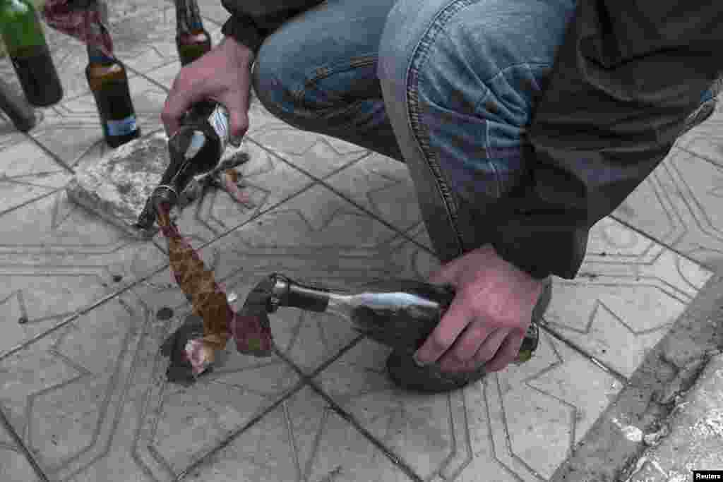 A Pro-Russian man prepares molotov cocktails near the town of Slovyansk, May 5, 2014.