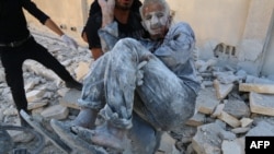 Thường dân được giải cứu khỏi đống đổ nát sau một vụ không kích ở Aleppo.