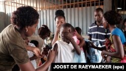 Un militaire angolais administre un vaccin de fièvre jaune à un enfant au marché de ‘Quilometro 30’ à Luanda, Angola, 16 fevrier 2016. Epa/ JOOST DE RAEYMAEKER