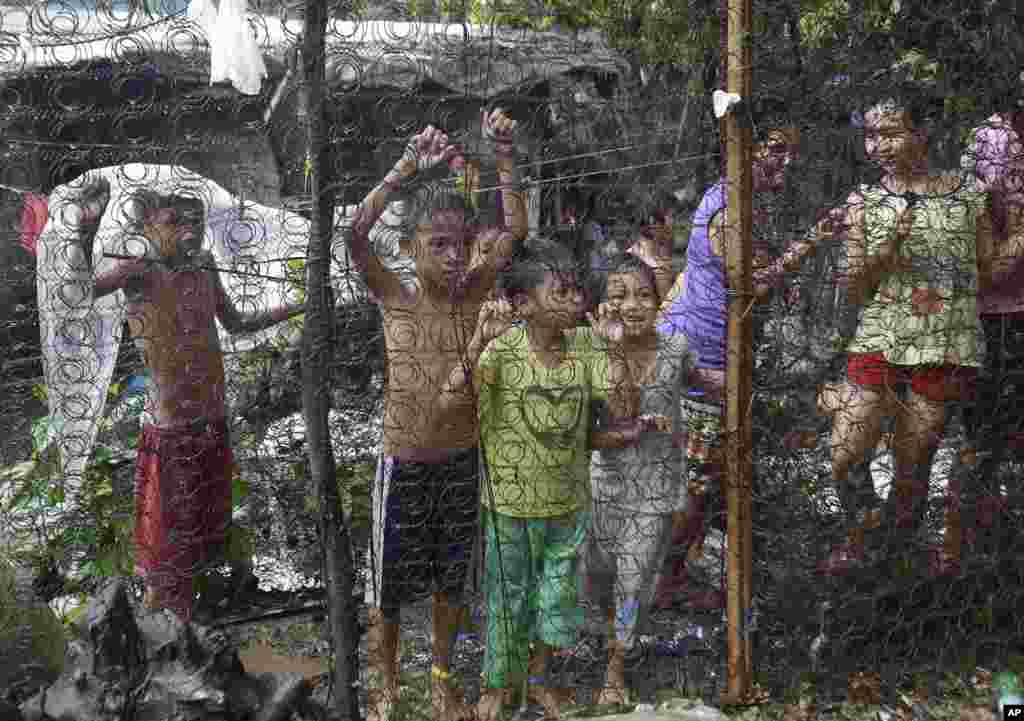 Anak-anak Filipina menonton operasi penggerebekan rumah tersangka bandar narkoba (tidak terlihat) di Quezon city, utara Manila.