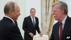 Ruski predsjednik Vladimir Putin rukuje se sa američkim savjetnikom za nacionalnu bezbjednost Johnom Boltonom, Kremlj, 27. jun 2018.