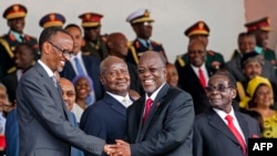 Tanzania's newly elected president John Magufuli (2ndR) shakes hands with Rwanda's president Paul Kagame (L) eyed by Zimbabwe's president Robert Mugabe (R) and Uganda's president Yoweri Museveni (2ndL) during the swearing in ceremony in Dar es Salaam, on Nov. 5, 2015.