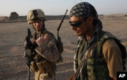FILE - A U.S. Marine talks with an Afghan interpreter during a joint patrol in Helmand province, southern Afghanistan, Sept. 19, 2009. Faisal Razmal worked as an interpreter for U.S. forces in Afghanistan for five years prior to coming to the U.S. under a Special Immigrant Visa (SIV) program.