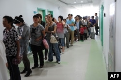 Chinese parents queue up to get their children inoculated against measles as part of a free 10-day nationwide campaign to urge parents to participate amid public fears about the safety of the inoculations in Hefei, in eastern China's Anhui province on Sept. 11, 2010.
