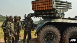 Des soldats des Forces armées de la République démocratique du Congo (FARDC) se tiennent près d'un lance-roquettes multiples mobile à Matombo, à 35 km au nord de Beni, au Nord-Kivu, le 13 janvier 2018.