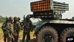 Des soldats des Forces armées de la République démocratique du Congo (FARDC) se tiennent près d'un lance-roquettes à Matombo,, au Nord-Kivu, le 13 janvier 2018.