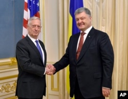 Ukrainian President, Petro Poroshenko, right, and U.S. Defense Secretary James Mattis shake hands during a meeting in Kyiv, Ukraine, Aug. 24, 2017.