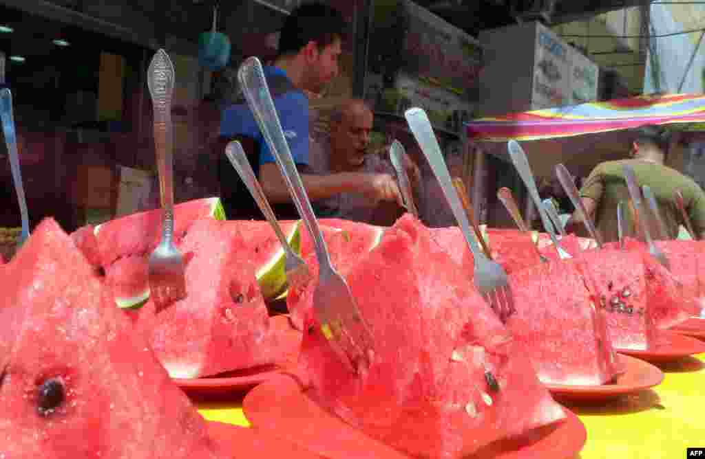 An Iraqi vendor sells watermelon slices on a hot day in Baghdad.