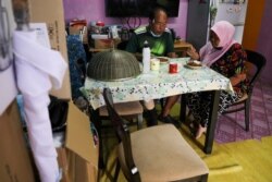 Halijah Naemat, 74, dan suaminya makan siang yang dimasak dengan makanan yang ditawarkan oleh anggota masyarakat di rumahnya selama penguncian di tengah wabah COVID-19, di Petaling Jaya, Malaysia, 6 Juli 2021. (Foto: REUTERS/Lim Huey T)