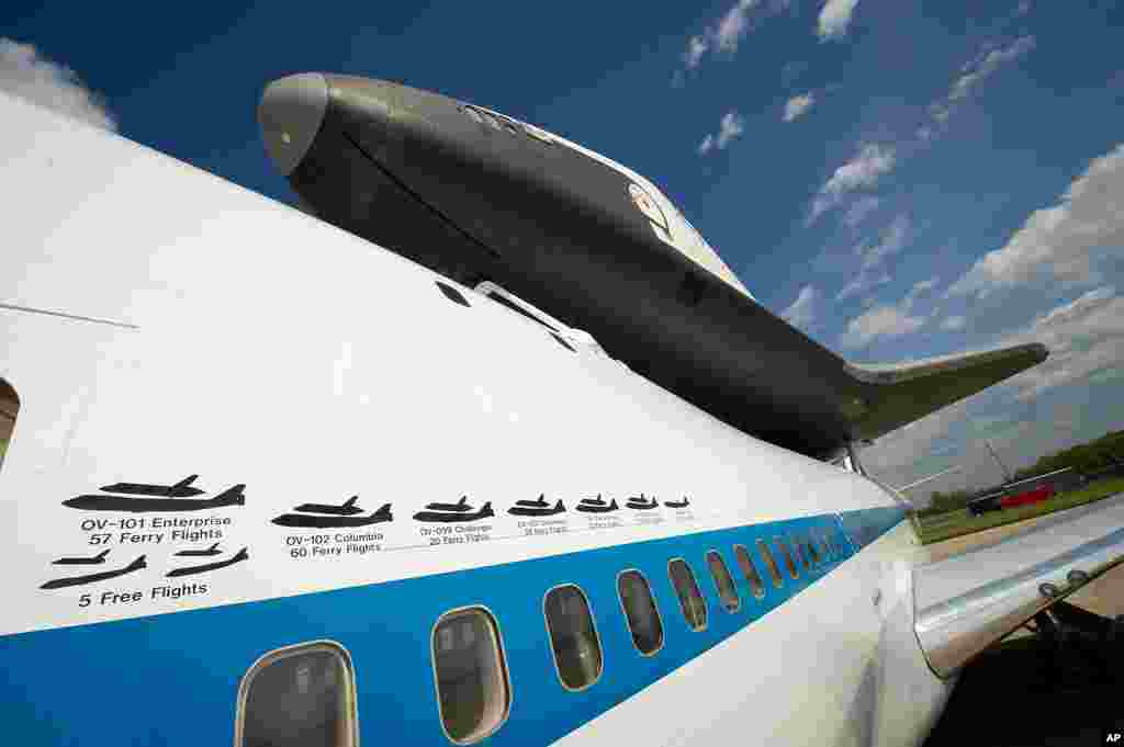 The space shuttle Enterprise is seen on top of the NASA 747 Shuttle Carrier Aircraft (SCA) at Washington Dulles International Airport in Sterling, Virginia, April 21, 2012. Painted graphics line the side of NASA 905 depicting the various ferry flights the
